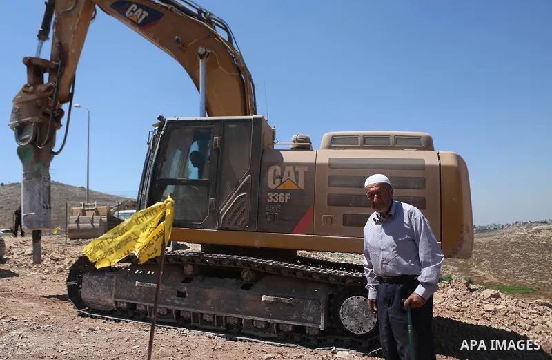 A Palestinian man tries to prevent Israeli excavator from clearing his land during a protest against Jewish settlements, near the village of Deir Qaddis near the West Bank city of Ramallah July 13, 2016. Photo by Shadi H...