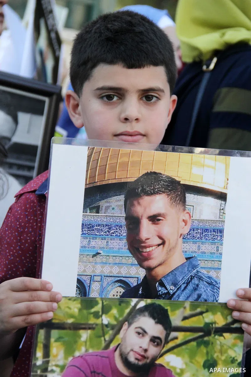 Relatives of Palestinian prisoners in Israeli jails take part in a protest against the decision of Israeli authorities minimize visits the Palestinian prisoners in front of Red cross office, in Jerusalem, on July 13, 201...