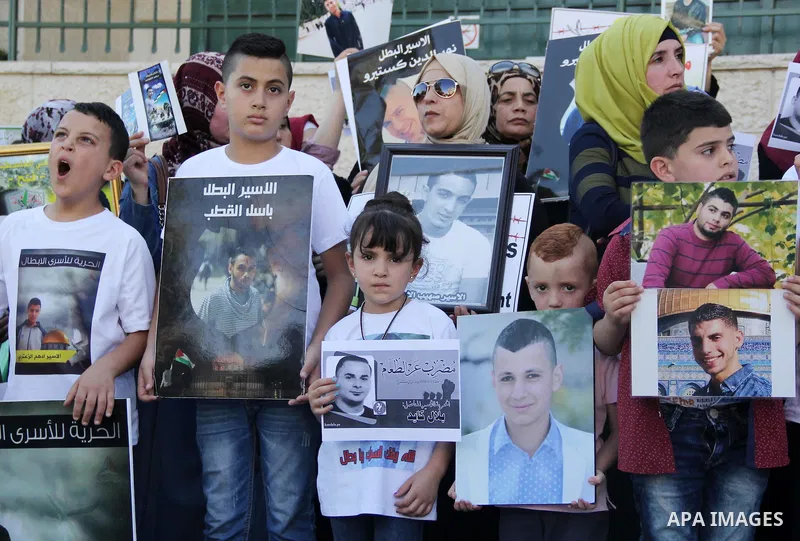 Relatives of Palestinian prisoners in Israeli jails take part in a protest against the decision of Israeli authorities minimize visits the Palestinian prisoners in front of Red cross office, in Jerusalem, on July 13, 201...