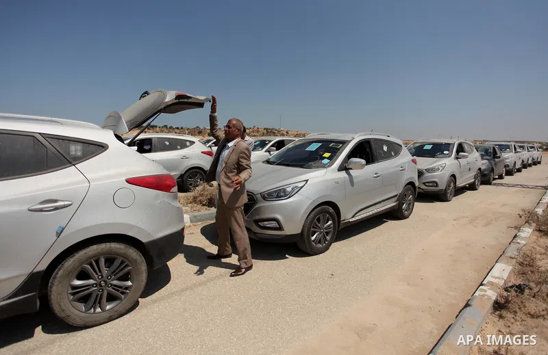 A Palestinian man inspects vehicles that came from Israel to serve the Gaza Strip market on July 14, 2016 in the Palestinian side of the Erez crossing with Israel. Israel opened the major Erez crossing point between Isra...