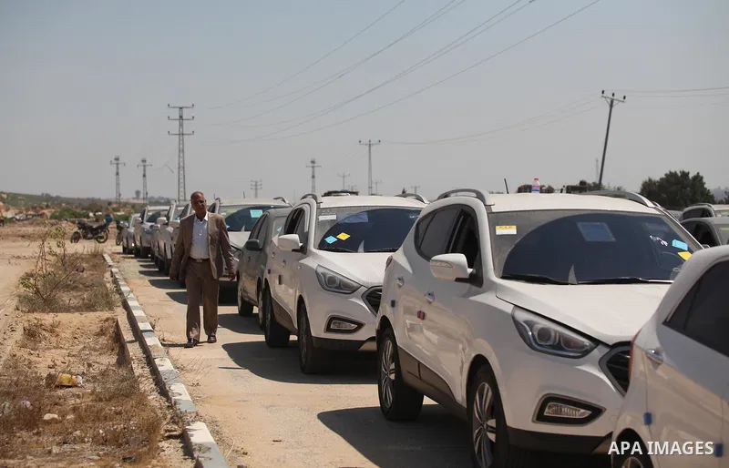 A Palestinian man inspects vehicles that came from Israel to serve the Gaza Strip market on July 14, 2016 in the Palestinian side of the Erez crossing with Israel. Israel opened the major Erez crossing point between Isra...