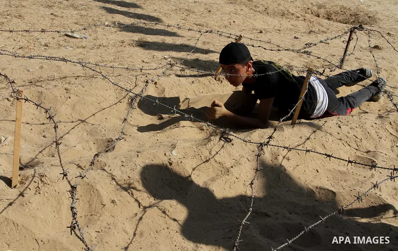 Young Palestinians take part in a military-style exercise at a summer camp organised by the Islamic Jihad movement in Khan Yunis in the southern Gaza Strip, during the youngsters' summer school vacation, on July 14, 2016...