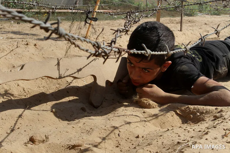 Young Palestinians take part in a military-style exercise at a summer camp organised by the Islamic Jihad movement in Khan Yunis in the southern Gaza Strip, during the youngsters' summer school vacation, on July 14, 2016...