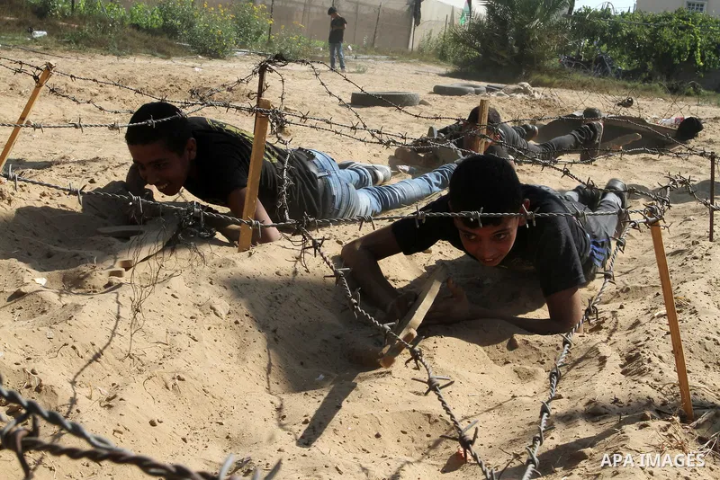 Young Palestinians take part in a military-style exercise at a summer camp organised by the Islamic Jihad movement in Khan Yunis in the southern Gaza Strip, during the youngsters' summer school vacation, on July 14, 2016...