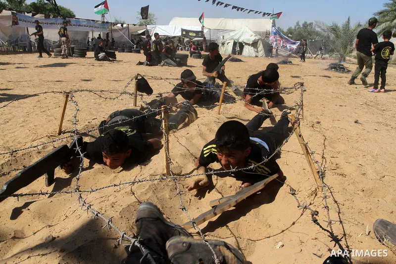 Young Palestinians take part in a military-style exercise at a summer camp organised by the Islamic Jihad movement in Khan Yunis in the southern Gaza Strip, during the youngsters' summer school vacation, on July 14, 2016...
