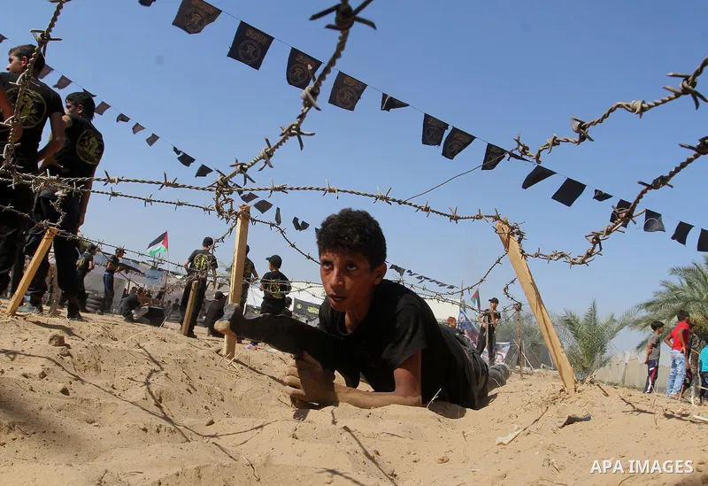 Young Palestinians take part in a military-style exercise at a summer camp organised by the Islamic Jihad movement in Khan Yunis in the southern Gaza Strip, during the youngsters' summer school vacation, on July 14, 2016...