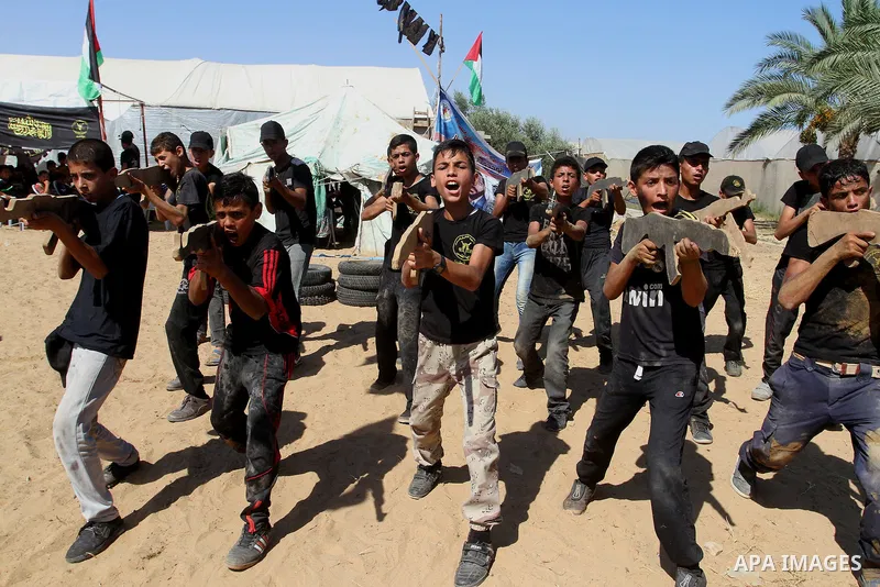 Young Palestinians take part in a military-style exercise at a summer camp organised by the Islamic Jihad movement in Khan Yunis in the southern Gaza Strip, during the youngsters' summer school vacation, on July 14, 2016...