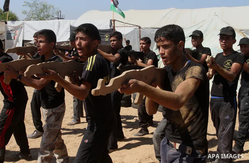 Young Palestinians take part in a military-style exercise at a summer camp organised by the Islamic Jihad movement in Khan Yunis in the southern Gaza Strip, during the youngsters' summer school vacation, on July 14, 2016...