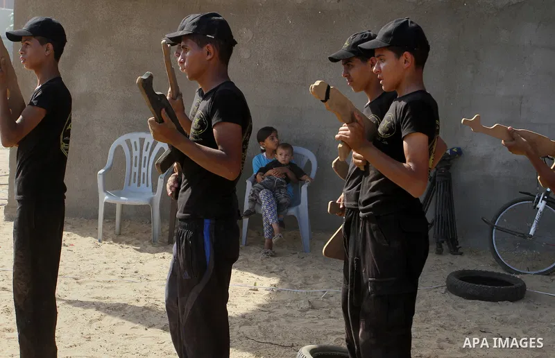 Young Palestinians take part in a military-style exercise at a summer camp organised by the Islamic Jihad movement in Khan Yunis in the southern Gaza Strip, during the youngsters' summer school vacation, on July 14, 2016...