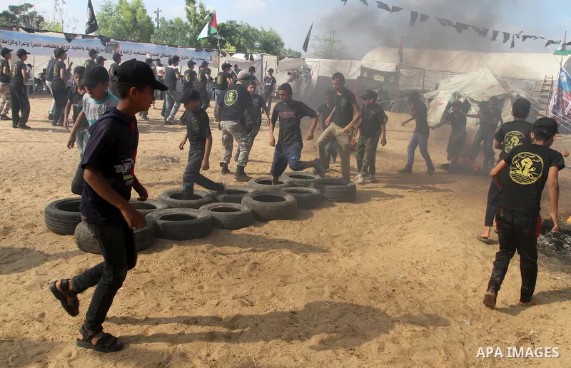 Young Palestinians take part in a military-style exercise at a summer camp organised by the Islamic Jihad movement in Khan Yunis in the southern Gaza Strip, during the youngsters' summer school vacation, on July 14, 2016...