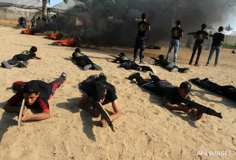 Young Palestinians take part in a military-style exercise at a summer camp organised by the Islamic Jihad movement in Khan Yunis in the southern Gaza Strip, during the youngsters' summer school vacation, on July 14, 2016...