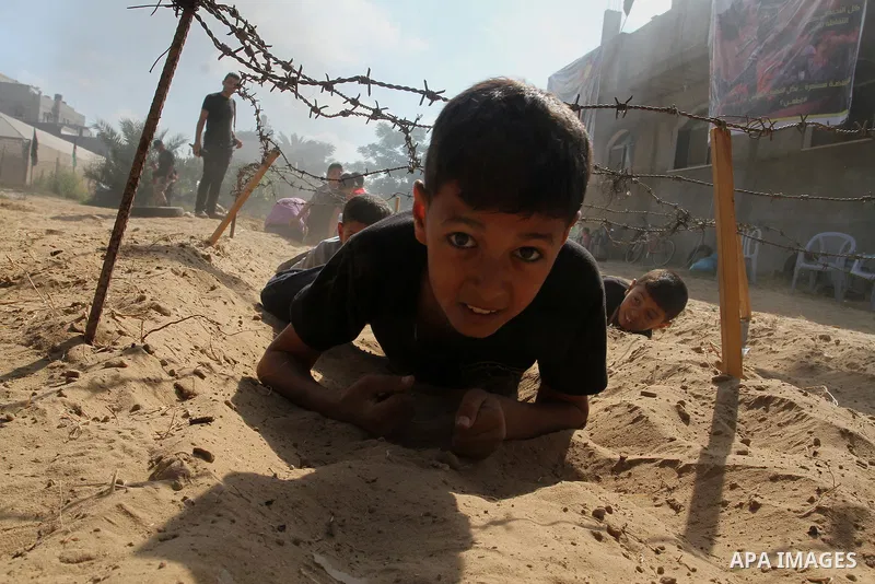 Young Palestinians take part in a military-style exercise at a summer camp organised by the Islamic Jihad movement in Khan Yunis in the southern Gaza Strip, during the youngsters' summer school vacation, on July 14, 2016...