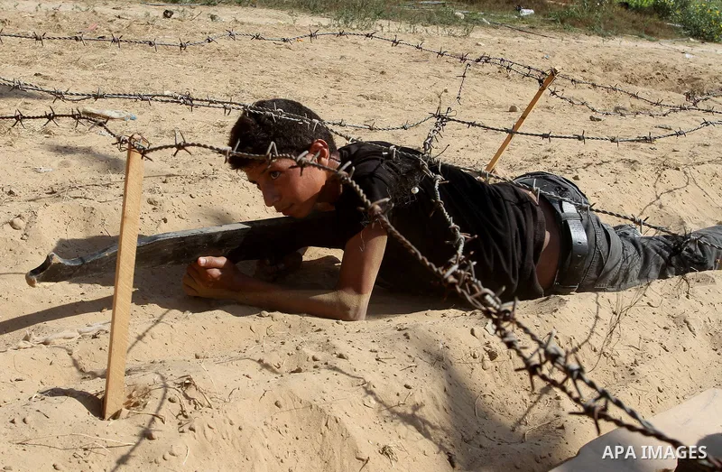 Young Palestinians take part in a military-style exercise at a summer camp organised by the Islamic Jihad movement in Khan Yunis in the southern Gaza Strip, during the youngsters' summer school vacation, on July 14, 2016...