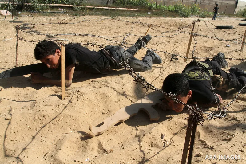 Young Palestinians take part in a military-style exercise at a summer camp organised by the Islamic Jihad movement in Khan Yunis in the southern Gaza Strip, during the youngsters' summer school vacation, on July 14, 2016...