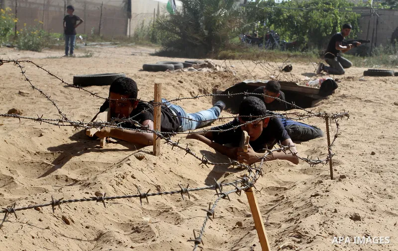 Young Palestinians take part in a military-style exercise at a summer camp organised by the Islamic Jihad movement in Khan Yunis in the southern Gaza Strip, during the youngsters' summer school vacation, on July 14, 2016...
