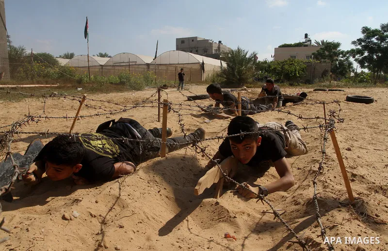 Young Palestinians take part in a military-style exercise at a summer camp organised by the Islamic Jihad movement in Khan Yunis in the southern Gaza Strip, during the youngsters' summer school vacation, on July 14, 2016...