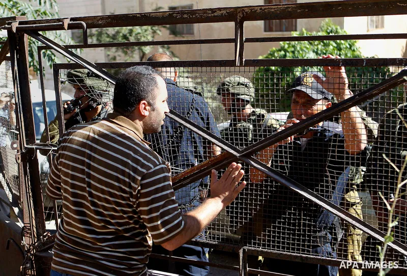 A Palestinian man argues with Israeli army soldiers as peace activists clean around Palestinian houses in Tal Rumaida in the West Bank city of Hebron July 15, 2016. Photo by Wisam Hashlamoun
