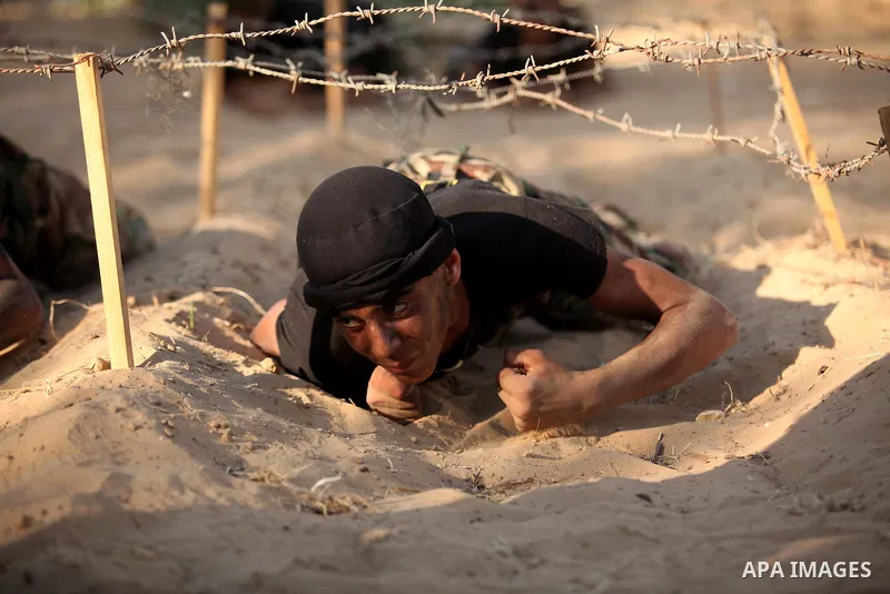 Palestinian youths take part in a military-style graduation ceremony at a summer camp organized by the Islamic Jihad Movement in Khan Younis in the southern Gaza Strip July 15, 2016. Photo by Ashraf Amra