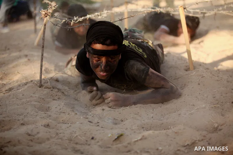 Palestinian youths take part in a military-style graduation ceremony at a summer camp organized by the Islamic Jihad Movement in Khan Younis in the southern Gaza Strip July 15, 2016. Photo by Ashraf Amra