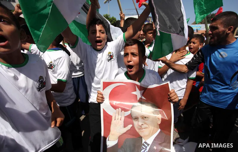 Palestinian supporters of the Hamas movement wave their national flag and Turkey's flag as they shout slogans against the military coup attempt in Turkey, during a demonstration in Gaza City, on July 16, 2016. Erdogan ba...