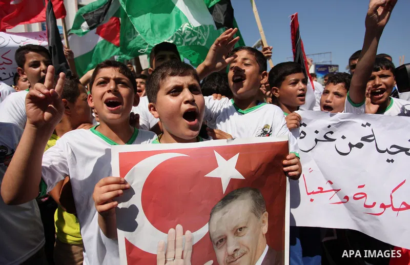 Palestinian supporters of the Hamas movement wave their national flag and Turkey's flag as they shout slogans against the military coup attempt in Turkey, during a demonstration in Gaza City, on July 16, 2016. Erdogan ba...