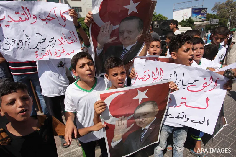 Palestinian supporters of the Hamas movement wave their national flag and Turkey's flag as they shout slogans against the military coup attempt in Turkey, during a demonstration in Gaza City, on July 16, 2016. Erdogan ba...