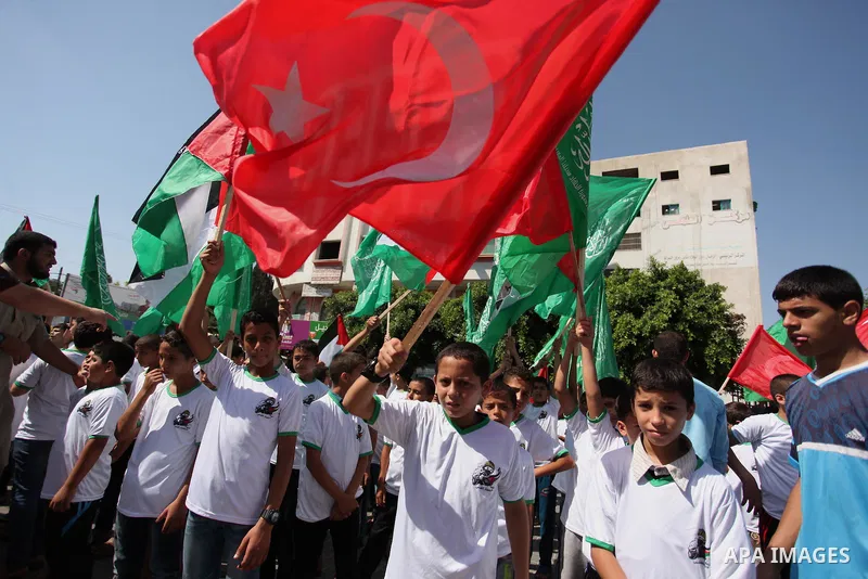 Palestinian supporters of the Hamas movement wave their national flag and Turkey's flag as they shout slogans against the military coup attempt in Turkey, during a demonstration in Gaza City, on July 16, 2016. Erdogan ba...