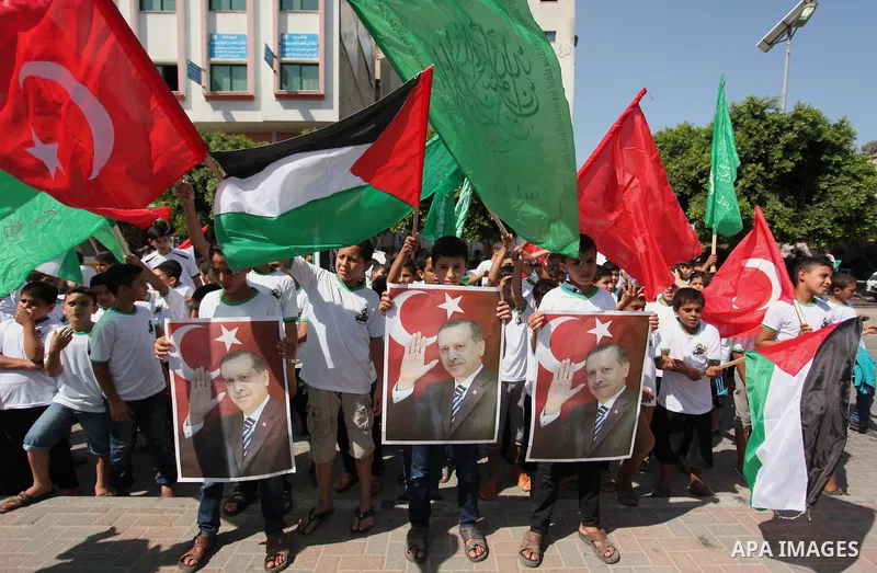 Palestinian supporters of the Hamas movement wave their national flag and Turkey's flag as they shout slogans against the military coup attempt in Turkey, during a demonstration in Gaza City, on July 16, 2016. Erdogan ba...