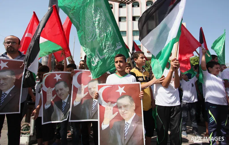 Palestinian supporters of the Hamas movement wave their national flag and Turkey's flag as they shout slogans against the military coup attempt in Turkey, during a demonstration in Gaza City, on July 16, 2016. Erdogan ba...