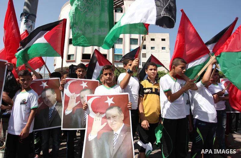 Palestinian supporters of the Hamas movement wave their national flag and Turkey's flag as they shout slogans against the military coup attempt in Turkey, during a demonstration in Gaza City, on July 16, 2016. Erdogan ba...