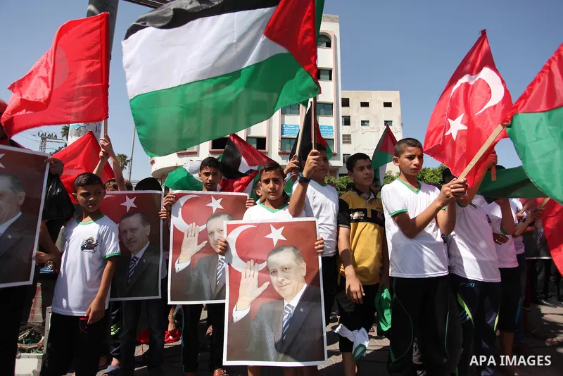 Palestinian supporters of the Hamas movement wave their national flag and Turkey's flag as they shout slogans against the military coup attempt in Turkey, during a demonstration in Gaza City, on July 16, 2016. Erdogan ba...
