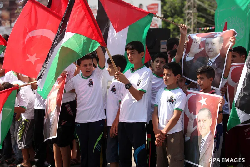 Palestinian supporters of the Hamas movement wave their national flag and Turkey's flag as they shout slogans against the military coup attempt in Turkey, during a demonstration in Gaza City, on July 16, 2016. Erdogan ba...