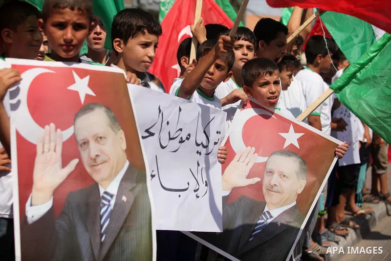 Palestinian supporters of the Hamas movement wave their national flag and Turkey's flag as they shout slogans against the military coup attempt in Turkey, during a demonstration in Gaza City, on July 16, 2016. Erdogan ba...