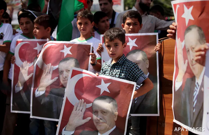 Palestinian supporters of the Hamas movement wave their national flag and Turkey's flag as they shout slogans against the military coup attempt in Turkey, during a demonstration in Gaza City, on July 16, 2016. Erdogan ba...