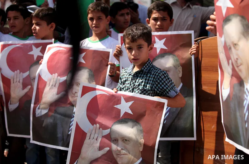 Palestinian supporters of the Hamas movement wave their national flag and Turkey's flag as they shout slogans against the military coup attempt in Turkey, during a demonstration in Gaza City, on July 16, 2016. Erdogan ba...