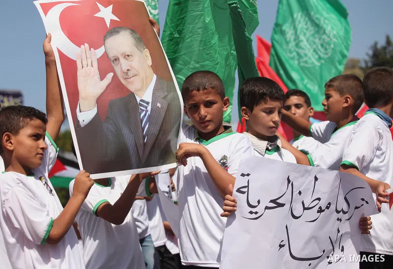Palestinian supporters of the Hamas movement wave their national flag and Turkey's flag as they shout slogans against the military coup attempt in Turkey, during a demonstration in Gaza City, on July 16, 2016. Erdogan ba...