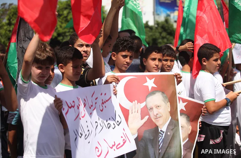Palestinian supporters of the Hamas movement wave their national flag and Turkey's flag as they shout slogans against the military coup attempt in Turkey, during a demonstration in Gaza City, on July 16, 2016. Erdogan ba...