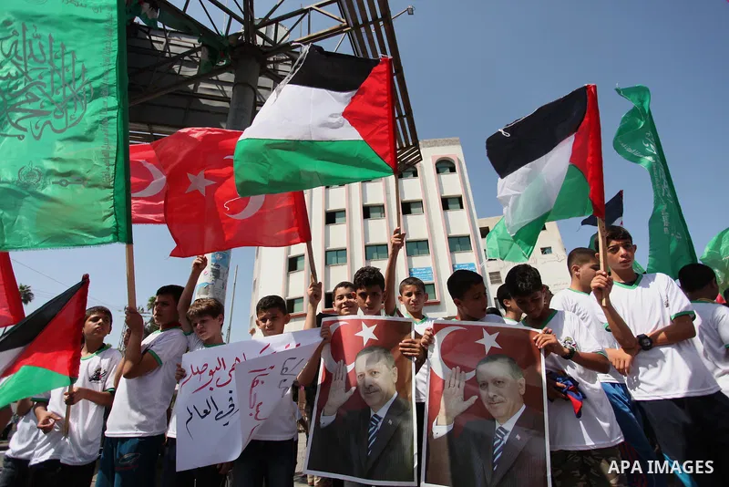 Palestinian supporters of the Hamas movement wave their national flag and Turkey's flag as they shout slogans against the military coup attempt in Turkey, during a demonstration in Gaza City, on July 16, 2016. Erdogan ba...