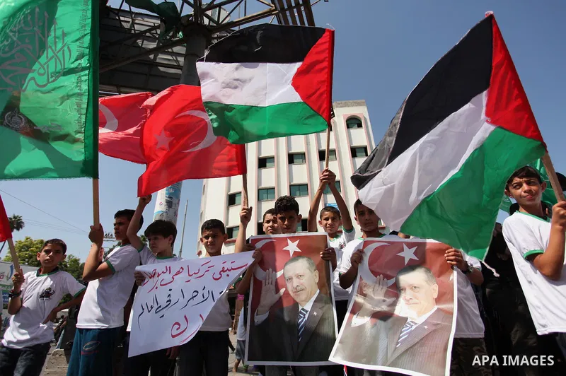 Palestinian supporters of the Hamas movement wave their national flag and Turkey's flag as they shout slogans against the military coup attempt in Turkey, during a demonstration in Gaza City, on July 16, 2016. Erdogan ba...