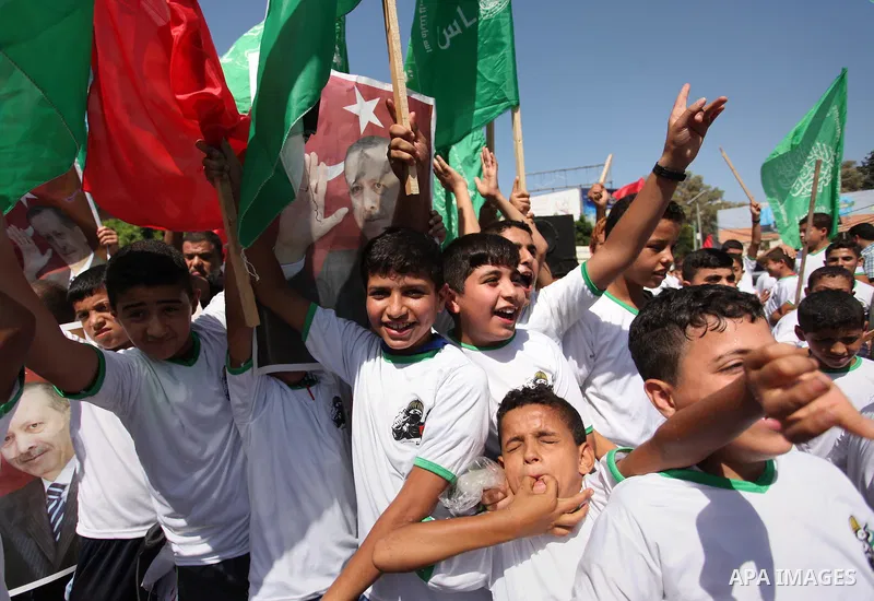 Palestinian supporters of the Hamas movement wave their national flag and Turkey's flag as they shout slogans against the military coup attempt in Turkey, during a demonstration in Gaza City, on July 16, 2016. Erdogan ba...