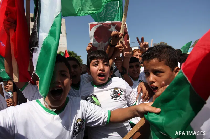 Palestinian supporters of the Hamas movement wave their national flag and Turkey's flag as they shout slogans against the military coup attempt in Turkey, during a demonstration in Gaza City, on July 16, 2016. Erdogan ba...