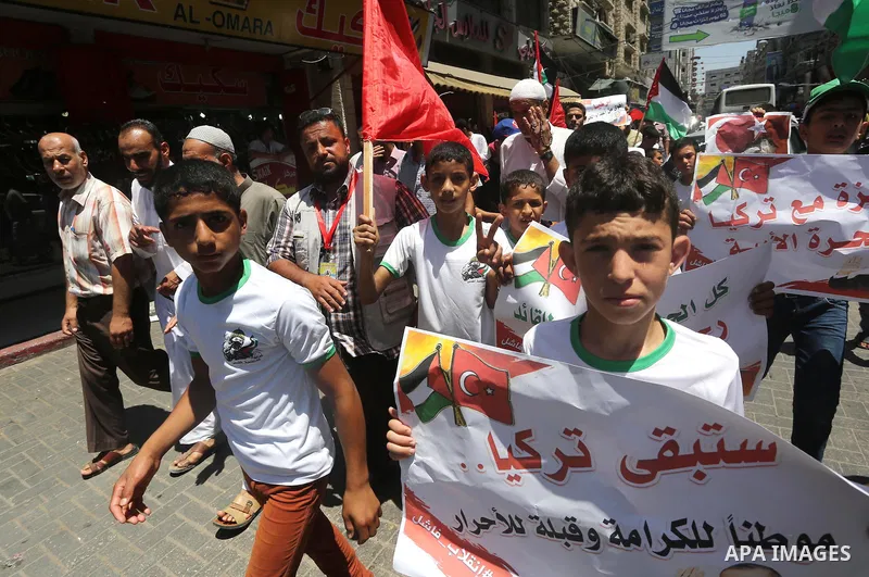 Palestinian supporters of the Hamas movement wave their national flag and Turkey's flag as they shout slogans against the military coup attempt in Turkey, during a demonstration in Gaza City, on July 16, 2016. Erdogan ba...