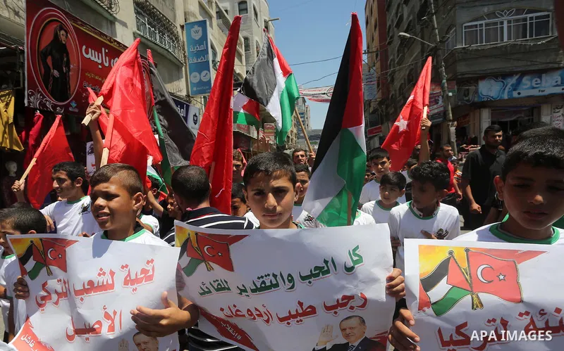 Palestinian supporters of the Hamas movement wave their national flag and Turkey's flag as they shout slogans against the military coup attempt in Turkey, during a demonstration in Gaza City, on July 16, 2016. Erdogan ba...