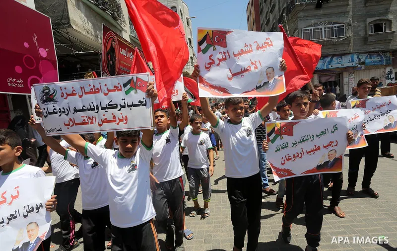 Palestinian supporters of the Hamas movement wave their national flag and Turkey's flag as they shout slogans against the military coup attempt in Turkey, during a demonstration in Gaza City, on July 16, 2016. Erdogan ba...