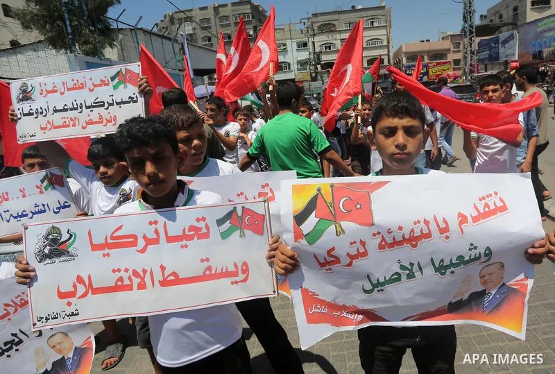 Palestinian supporters of the Hamas movement wave their national flag and Turkey's flag as they shout slogans against the military coup attempt in Turkey, during a demonstration in Gaza City, on July 16, 2016. Erdogan ba...