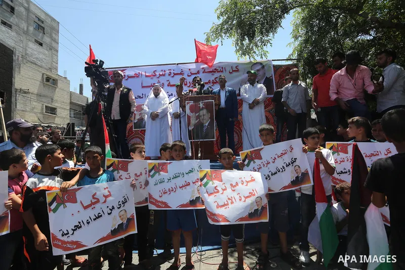 Palestinian supporters of the Hamas movement wave their national flag and Turkey's flag as they shout slogans against the military coup attempt in Turkey, during a demonstration in Gaza City, on July 16, 2016. Erdogan ba...