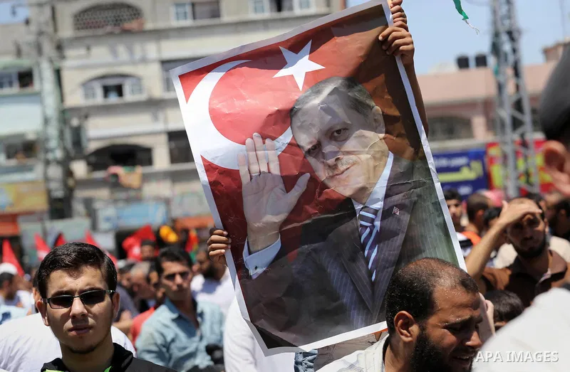 Palestinian supporters of the Hamas movement wave their national flag and Turkey's flag as they shout slogans against the military coup attempt in Turkey, during a demonstration in Gaza City, on July 16, 2016. Erdogan ba...