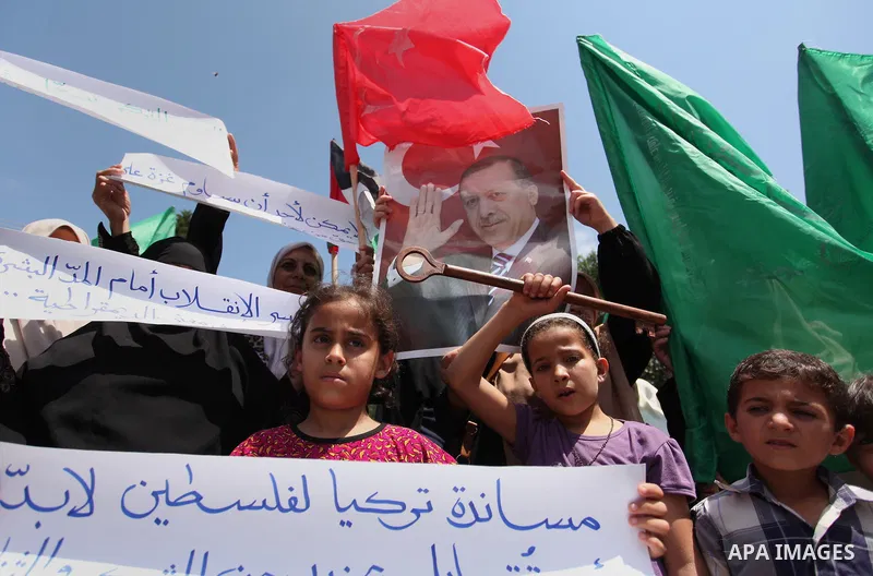 Palestinian supporters of the Hamas movement hold portraits of Turkish President Recep Tayyip Erdogan as they shout slogans against the military coup attempt in Turkey, during a demonstration in Gaza City, on July 17, 20...