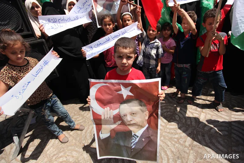 Palestinian supporters of the Hamas movement hold portraits of Turkish President Recep Tayyip Erdogan as they shout slogans against the military coup attempt in Turkey, during a demonstration in Gaza City, on July 17, 20...