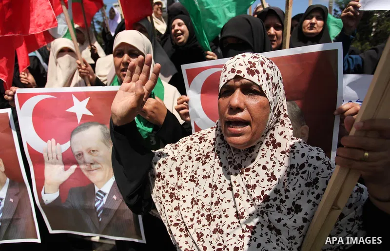 Palestinian supporters of the Hamas movement hold portraits of Turkish President Recep Tayyip Erdogan as they shout slogans against the military coup attempt in Turkey, during a demonstration in Gaza City, on July 17, 20...